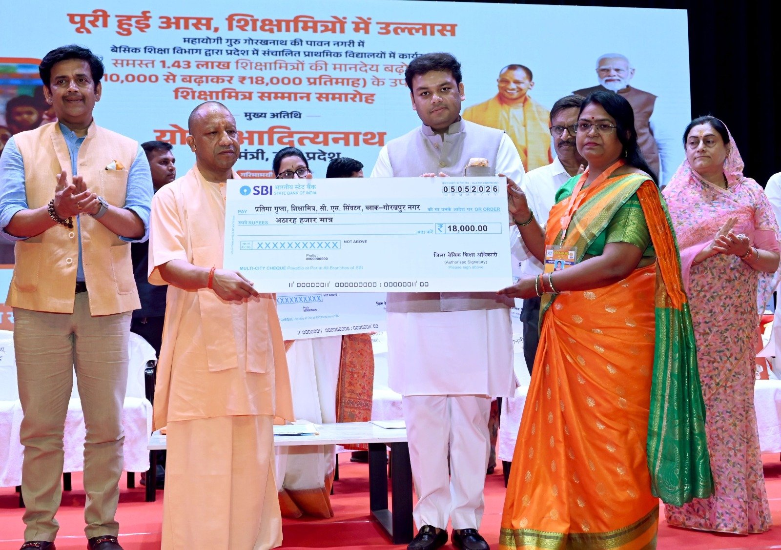 गोरखपुर में शिक्षामित्र सम्मान समारोह के दौरान मुख्यमंत्री योगी आदित्यनाथ द्वारा ₹18,000 मानदेय का प्रतीकात्मक चेक वितरण